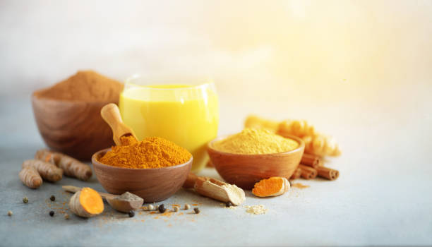 istock Yellow turmeric latte drink. Golden milk with cinnamon, turmeric, ginger over grey background. Copy space. 1149544864