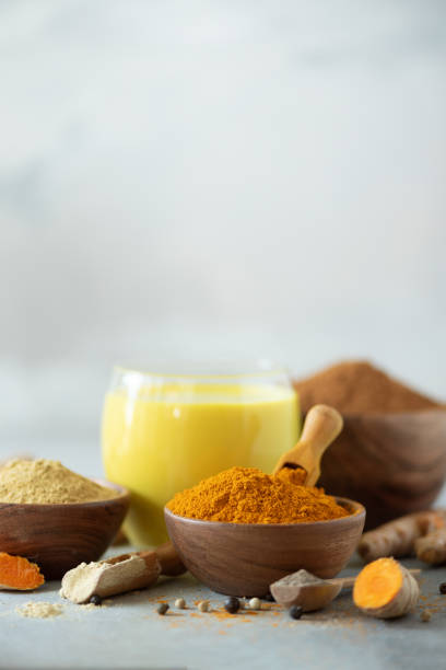 istock Yellow turmeric latte drink. Golden milk with cinnamon, turmeric, ginger over grey background. Copy space. 1149544876