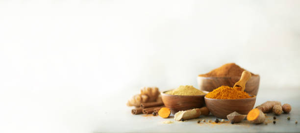 Ingredients for hot ayurvedic drink. Turmeric powder, curcuma root, cinnamon, ginger, lemon over grey background. Copy space, square crop. Spices for alternative medicine Ingredients for hot ayurvedic drink. Turmeric powder, curcuma root, cinnamon, ginger, lemon over grey background. Copy space, square crop. Spices for alternative medicine. anti inflammatory stock pictures, royalty-free photos & images