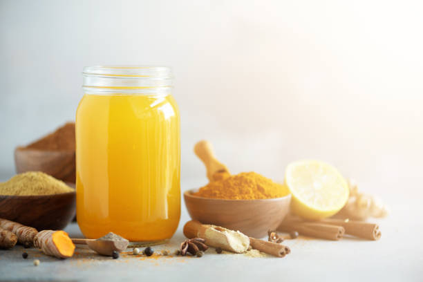 istock Ingredients for orange turmeric drink on grey concrete background. Lemon water with ginger, curcuma, black pepper. Vegan hot drink concept 1149544895