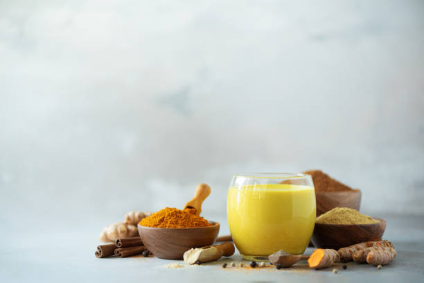 istock Ingredients for turmeric latte. Turmeric powder, curcuma root, cinnamon, ginger over grey background. Copy space, square crop. Spices for ayurvedic treatment. Alternative medicine concept. 1149544898