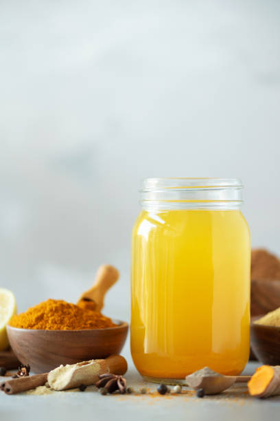 Ingredients for orange turmeric drink on grey concrete background. Lemon water with ginger, curcuma, black pepper. Vegan hot drink concept stock photo