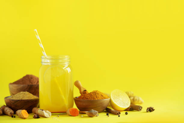 istock Ingredients for orange turmeric drink on yellow background. Lemon water with ginger, curcuma, black pepper. Vegan hot drink concept 1149544912