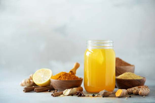 istock Ingredients for orange turmeric drink on grey concrete background. Lemon water with ginger, curcuma, black pepper. Vegan hot drink concept 1149544917