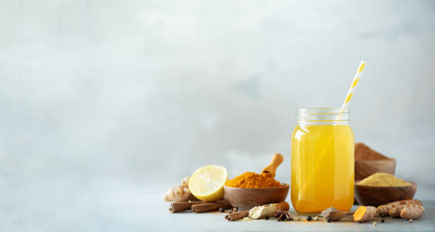 istock Ingredients for orange turmeric drink on grey concrete background. Lemon water with ginger, curcuma, black pepper. Vegan hot drink concept 1149544918