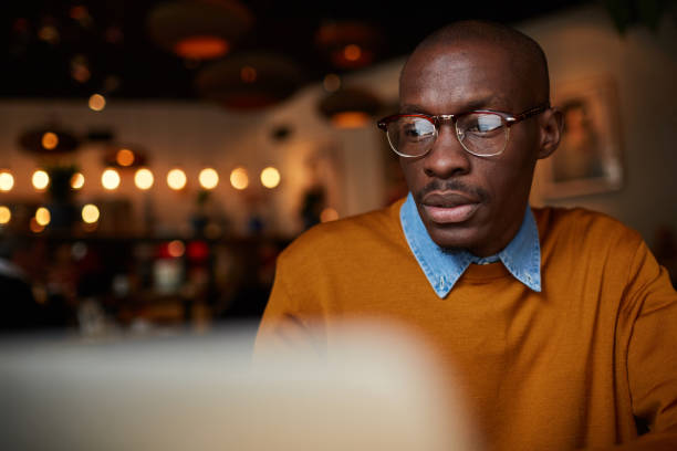African Man Working with Laptop in Cafe