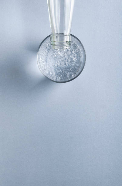agua de bebida fresca de la botella y un vaso de agua con gas en un fondo vacío moderno azul claro. espacio para el texto de arriba. maqueta para un concepto saludable - fuente de soda fotografías e imágenes de stock
