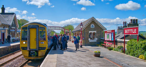 定住駅での観光客は、カーライルへの列車に乗るのを待つ、彼らの道に沿って有名な ribblehead の高架橋を渡るように設定 - diesel locomotive ストックフォトと画像