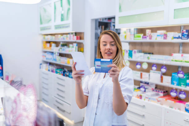 istock Beautiful smiling female pharmacist working in a pharmacy (or drugstore) with customer friendly attitude 1149549345