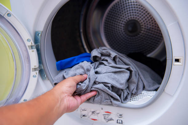 istock Hands are putting clothes into the washing machine 1149549609