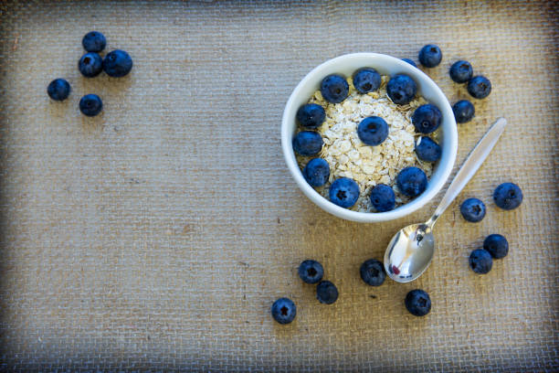 Yogurt wit hoatmeal and blueberry in a bowl isolated on a cloth background.