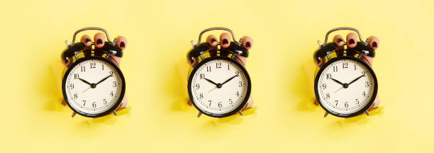 istock Seamless pattern of hands holding black alarm clock through hole in yellow paper background. Wake up alert concept. Morning routine. Minimalist style design. 1149553018