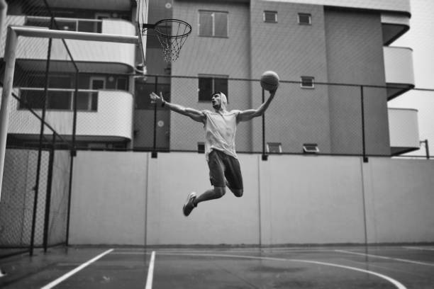image of an athletic young man slam dunking on a rainy day - basketball sport storm star imagens e fotografias de stock