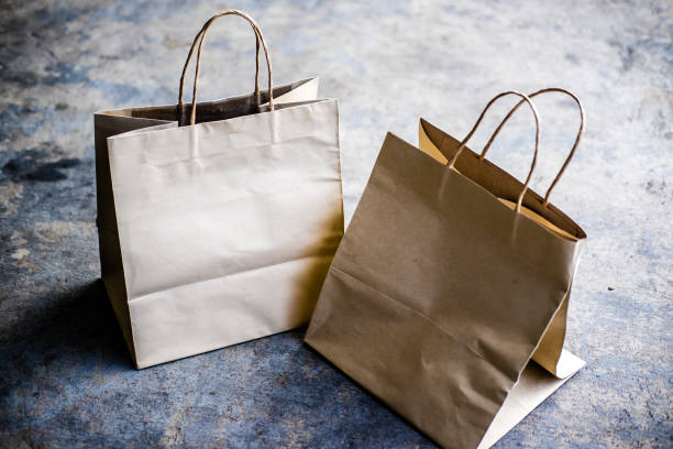 istock Kraft paper shopping bags on cement background 1149559391