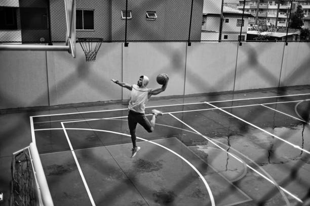 athletic young man slam dunking on a rainy weather - basketball sport storm star imagens e fotografias de stock