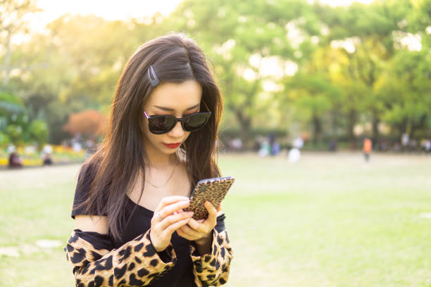istock Women in park playing with her phone 1149559634