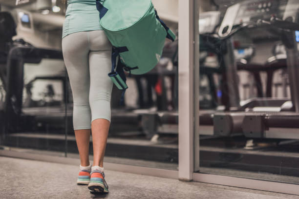 Close up of sole of shoe walking in gym. Close up of unknown woman whit the training bag entering in training centre. walking into glass door stock pictures, royalty-free photos & images