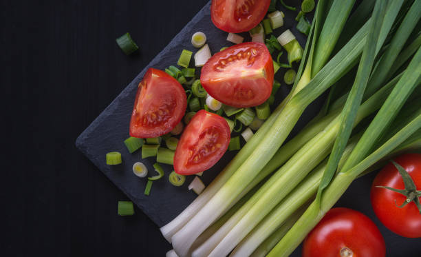 Freshly picked homemade tomatoes and spring onions. Close-up of the salad.