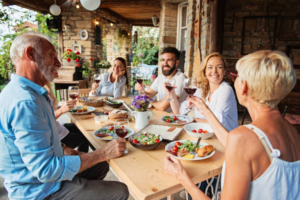 Family cheering over the dining table outdoors stock photo