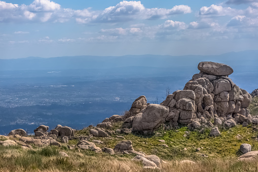 View from the top of the Caramulo mountains over the Estrela mountains, granitic rocks and undergrowth in Portugal