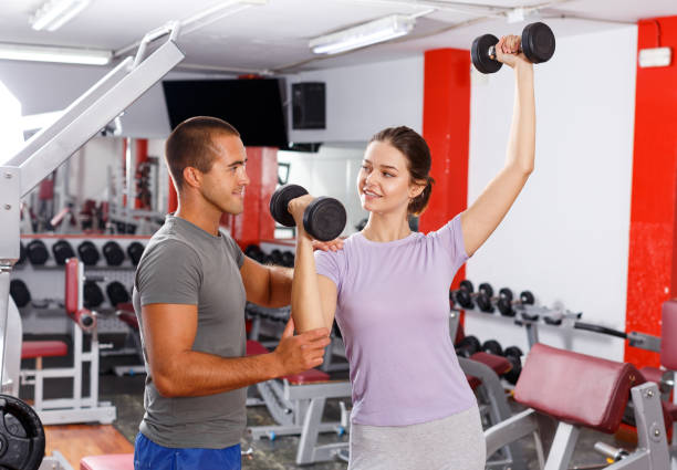 istock Woman and trainer doing exercises with dumbbells with 1149569524