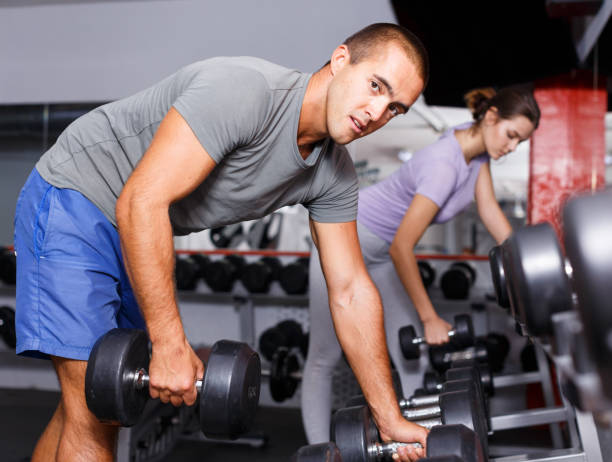 istock Man taking heavy sports dumbbell 1149569576