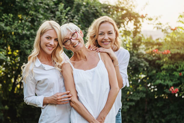 three women enjoying outdoors, talking and laughing - family senior adult healthy lifestyle happiness imagens e fotografias de stock