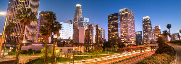 los angeles city skyline panorama over the freeway at night - hollywood california skyline city of los angeles panoramic imagens e fotografias de stock