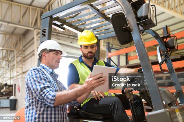 Manager Showing Digital Tablet To Manual Worker Stock Photo - Download Image Now - Forklift, Manager, Digital Tablet