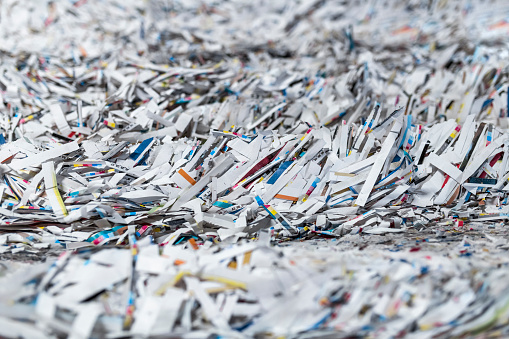 Close-up of shredded papers in printing press.