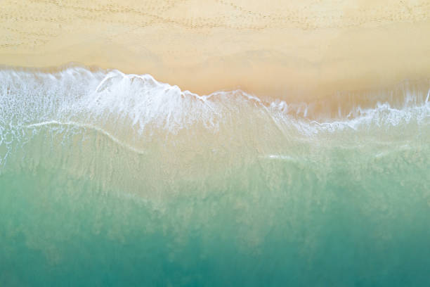 vue aérienne de l’onde océanique turquoise atteignant le littoral. belle plage tropicale de la vue de dessus. mer d’andaman en thaïlande. concept de vacances de vacances d’été - vague photos photos et images de collection