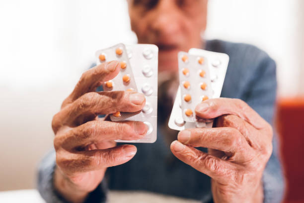 istock Elderly man holding pills 1149576161
