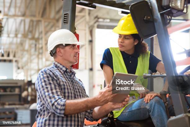 Forklift Driver Looking At Manager In Industry Stock Photo - Download Image Now - Manufacturing Occupation, Discussion, Serious