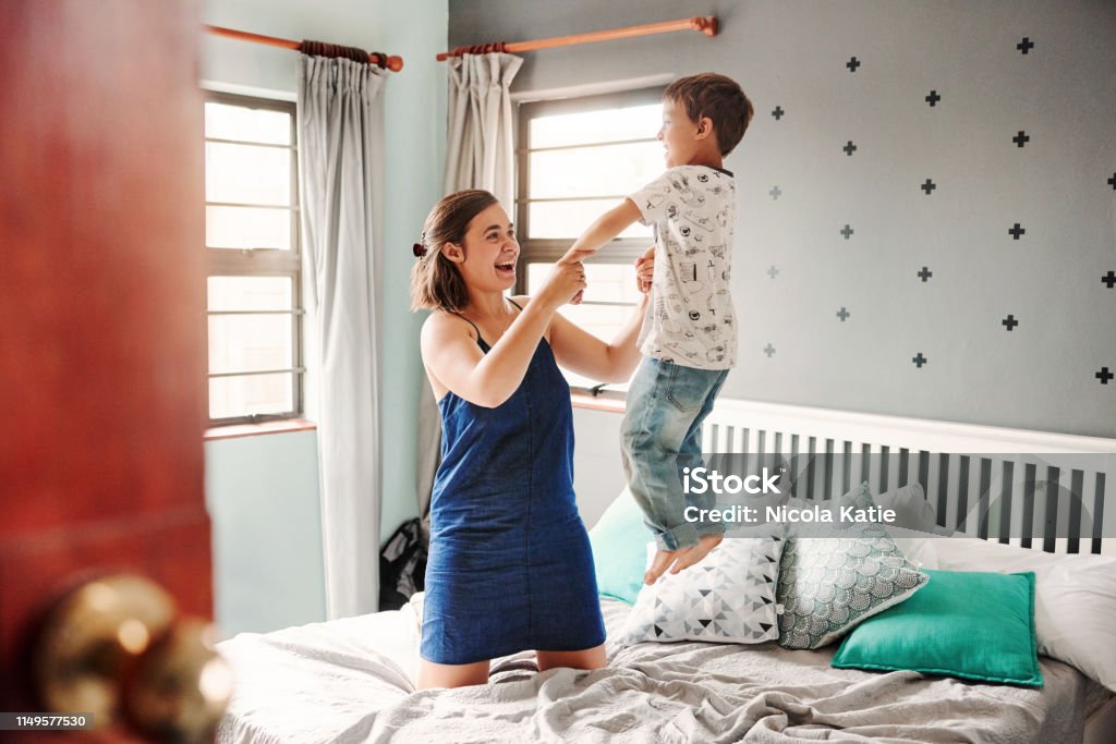 We have the best of times together Shot of a beautiful young mother playing with her son in the bedroom at home Bed - Furniture Stock Photo