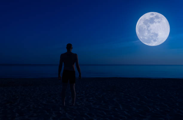 istock Shirtless man on the beach at night 1149579081