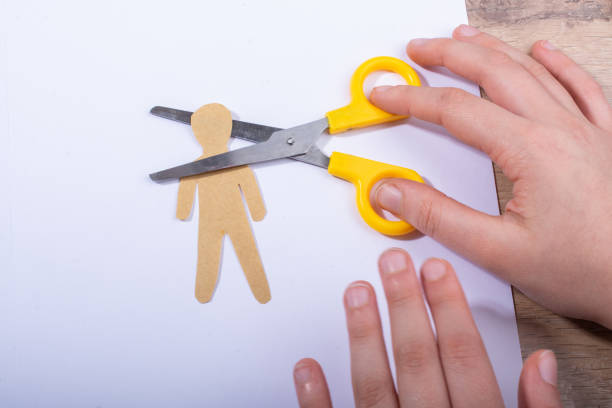 istock Hand holdig scissors cutting paper man's head on white paper 1149579177