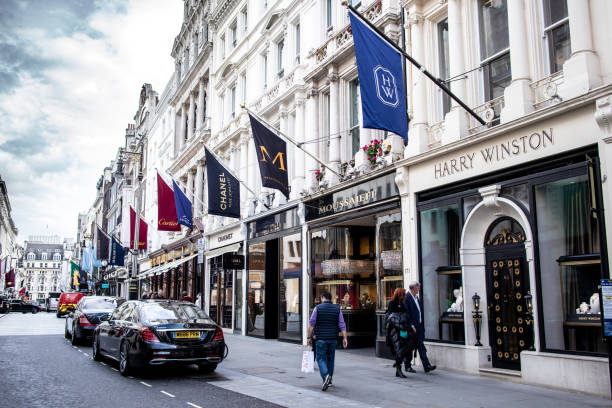 people walking by high end exclusive jewellery stores such as chanel, cartier in new bond, london, england - retail london england uk people imagens e fotografias de stock