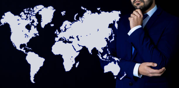 istock businessman and world map on dark background 1149583859
