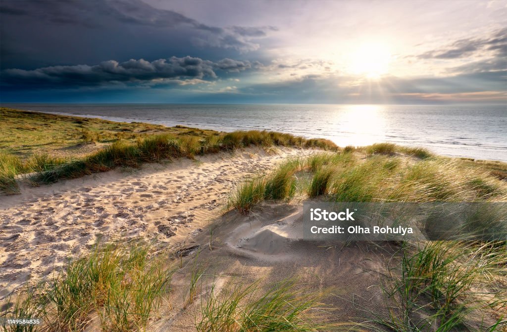 sunshine over sand path on dune to North sea beach Beach Stock Photo