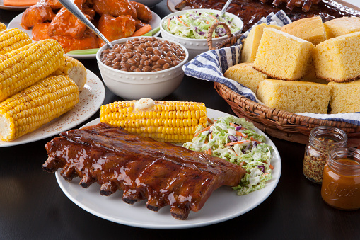 a plate of pork rib barbecue surrounded by fresh sides ready to be served