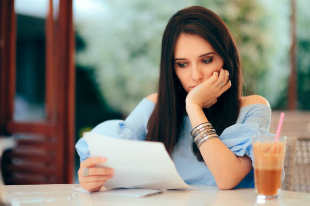 istock Worried Woman Reading Document Papers in a Restaurant 1149589140