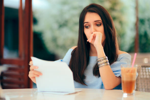 istock Worried Woman Reading Document Papers in a Restaurant 1149589149