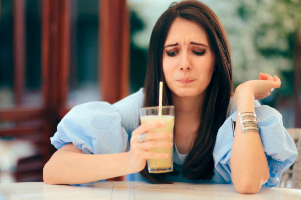 Woman Tasting Sour Lemonade Drink in a Restaurant Supertaster person reacting to freshly squeezed lemon juice beverage sour face stock pictures, royalty-free photos & images