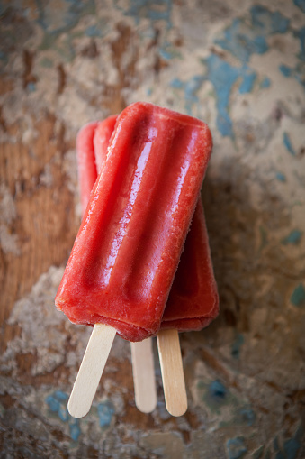 a stack of berry popsicles on a unique background
