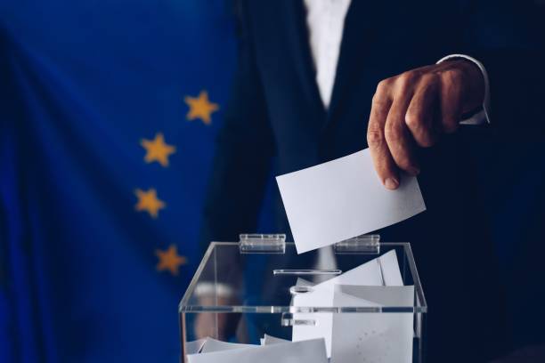 istock EU elections. Man throwing his vote into the ballot box. 1149591745