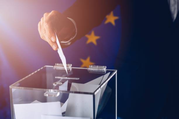 istock EU elections. Man throwing his vote into the ballot box. 1149591794