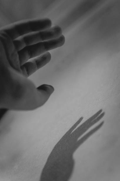 istock Hand and her shadow on the wall. Black and white. Monochrome 1149595069