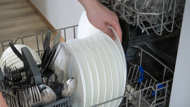 istock Dishware inside built-in dishwasher and person hand . Dishwashing machine rack 1149596510