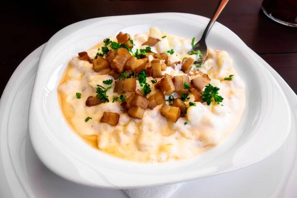 istock Potato dumplings in creamy cheese sauce with bacon on plate.. 1149600912