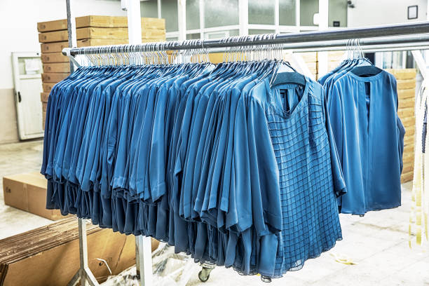 t-shirts hanging on a rack in clothing factory - fotografia de stock